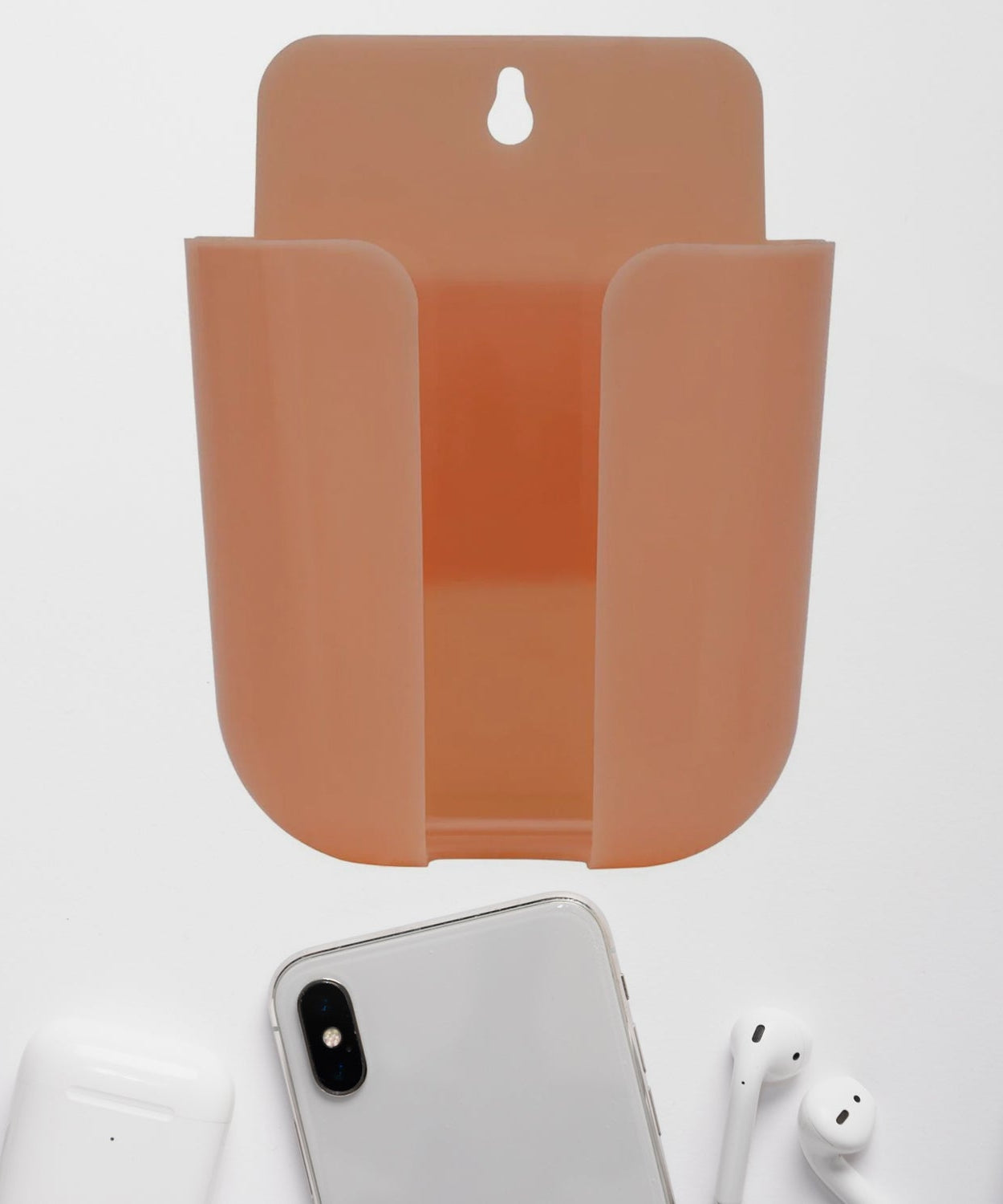 Multicolour wall-mounted storage box for remotes and small items.