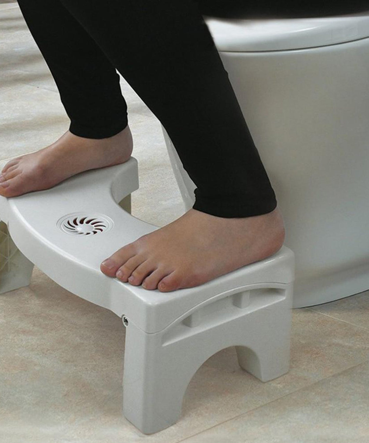 Space-saving folding toilet stool in white, with non-slip grip.