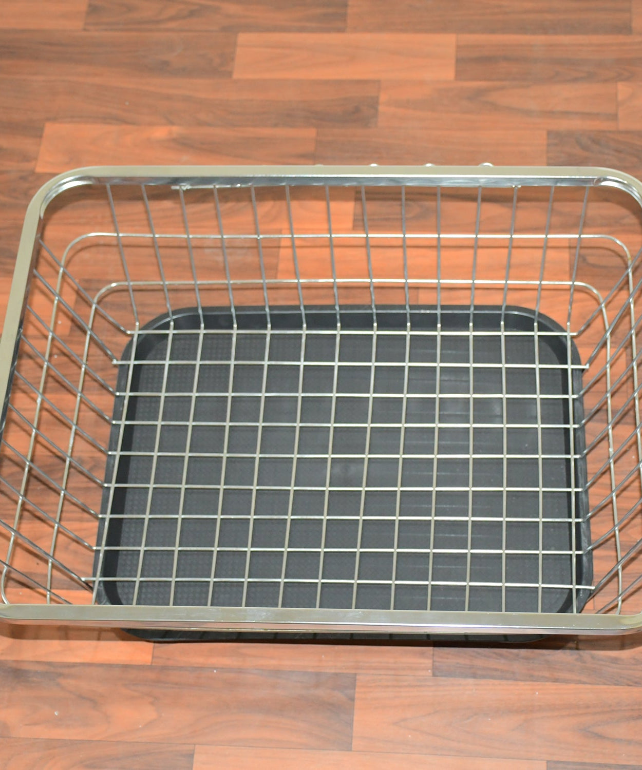 Close-up of stainless steel dish drainer rack with drip tray