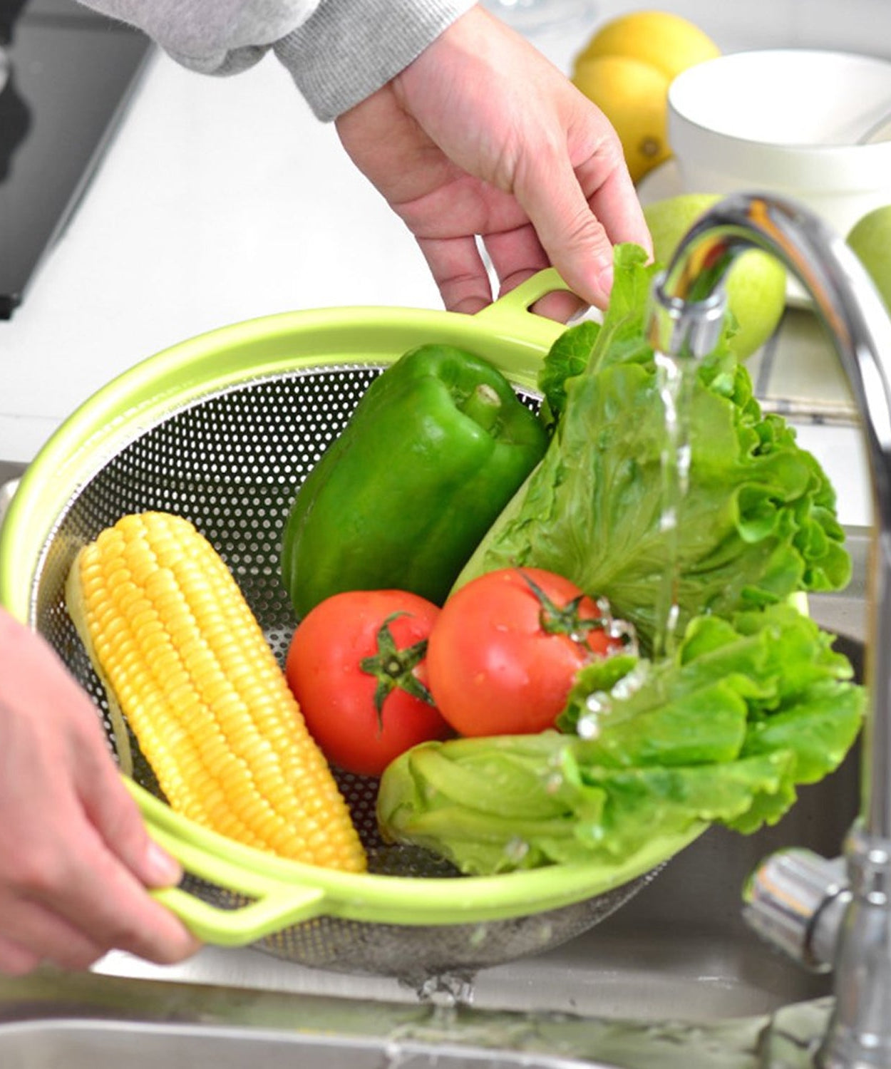 Large stainless steel colander with green handle
