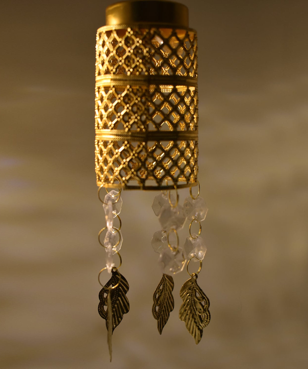 Golden jhoomer with fancy decorative elements.