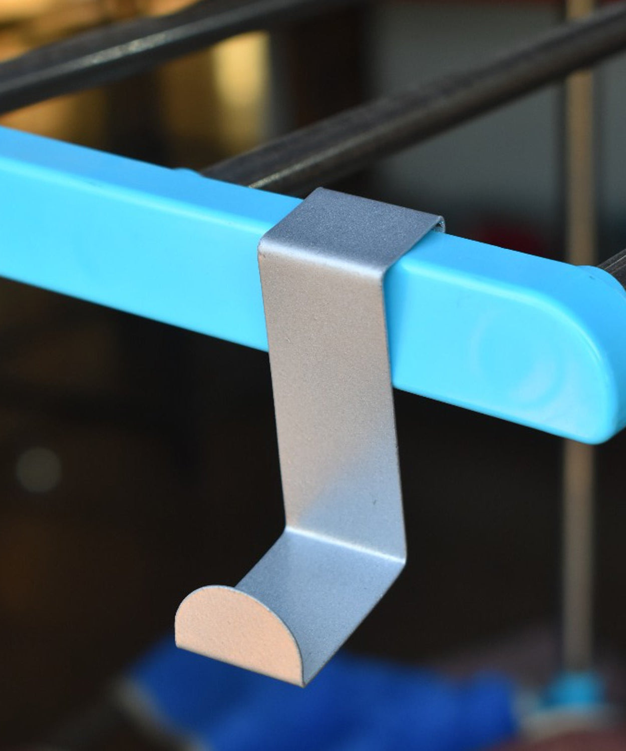 Z shape door hook with clothes hanging from it.