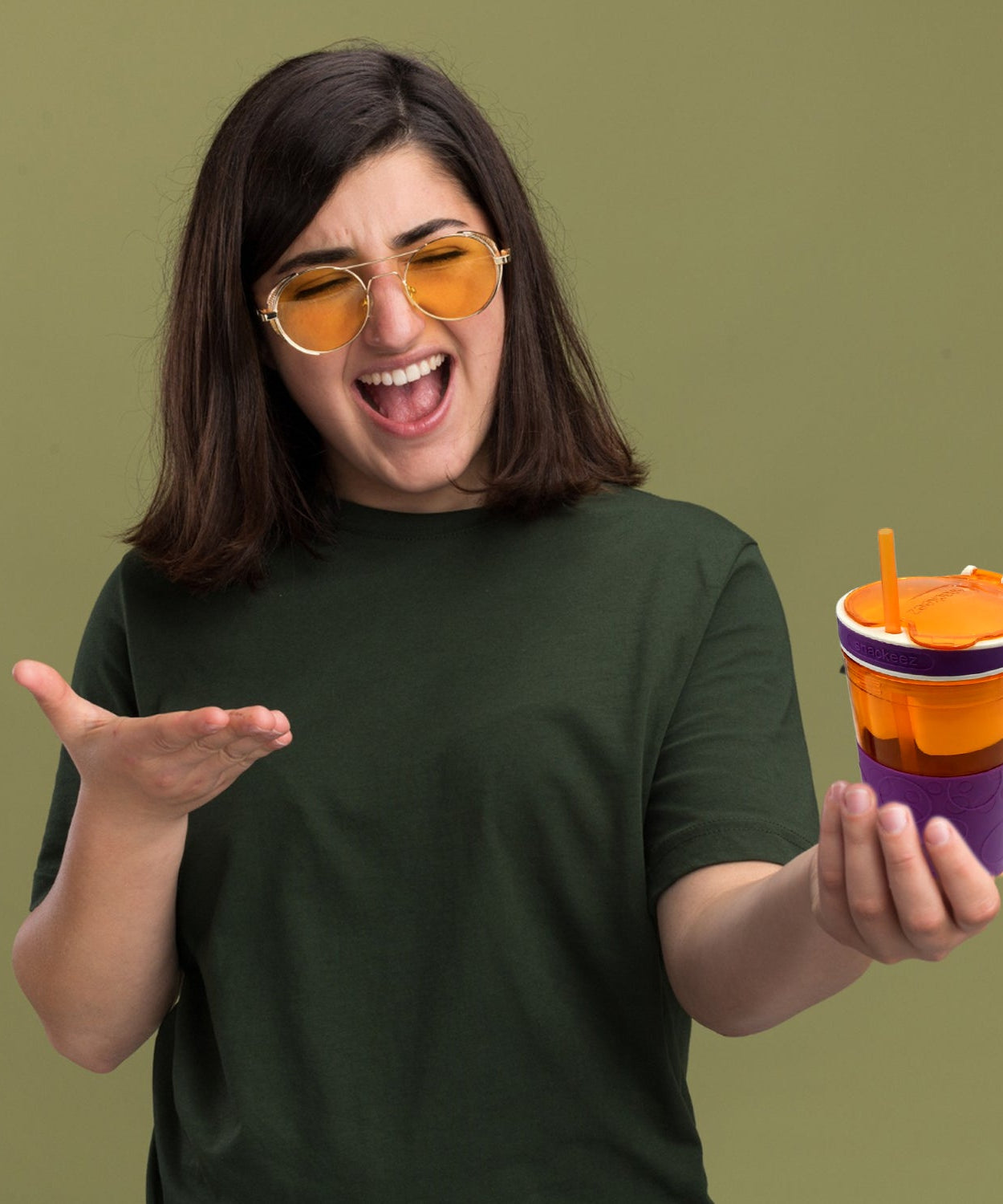 Portable snack and drink container, featuring a cup and snack compartment in one.