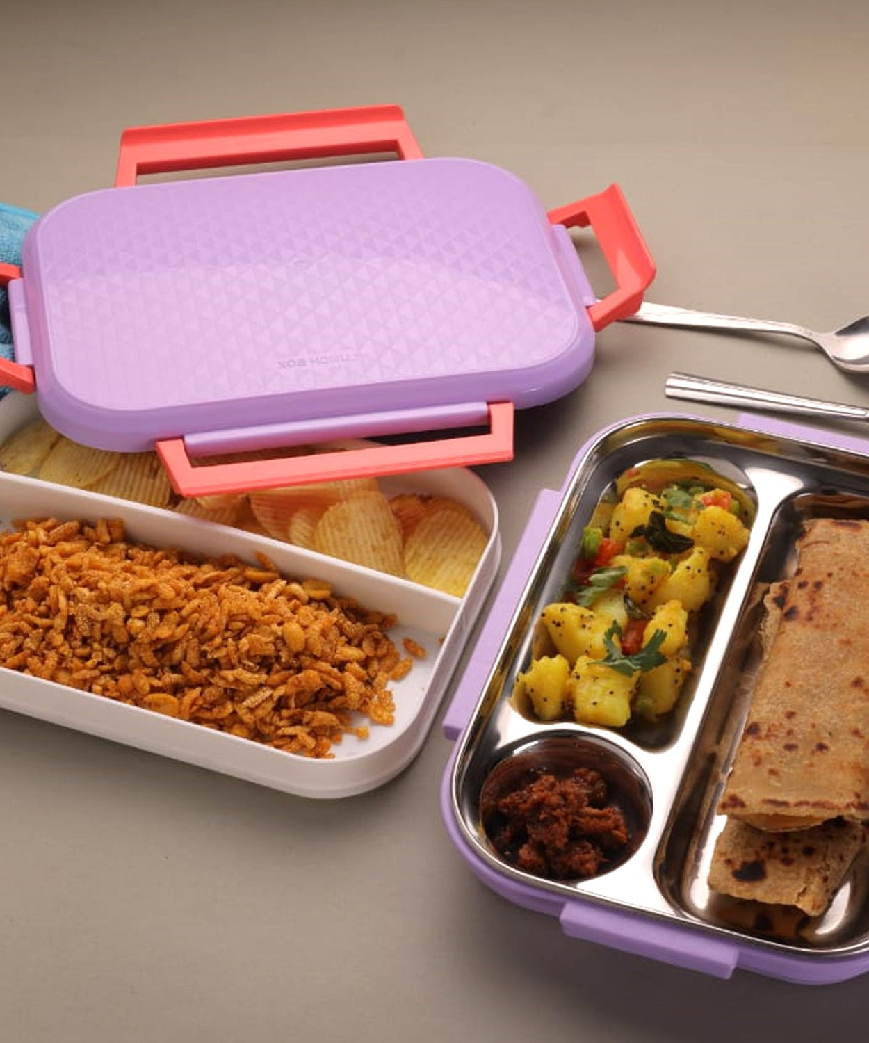 Multi-compartment lunch box with steel plates and a lid.