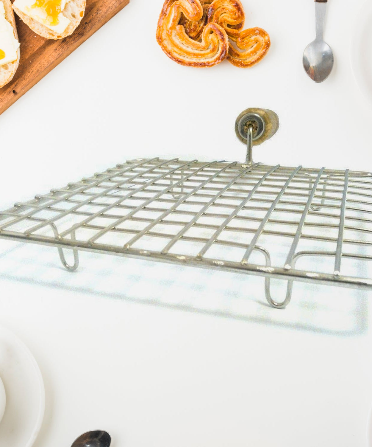 Stainless steel papad jali with square shape and wooden handle.