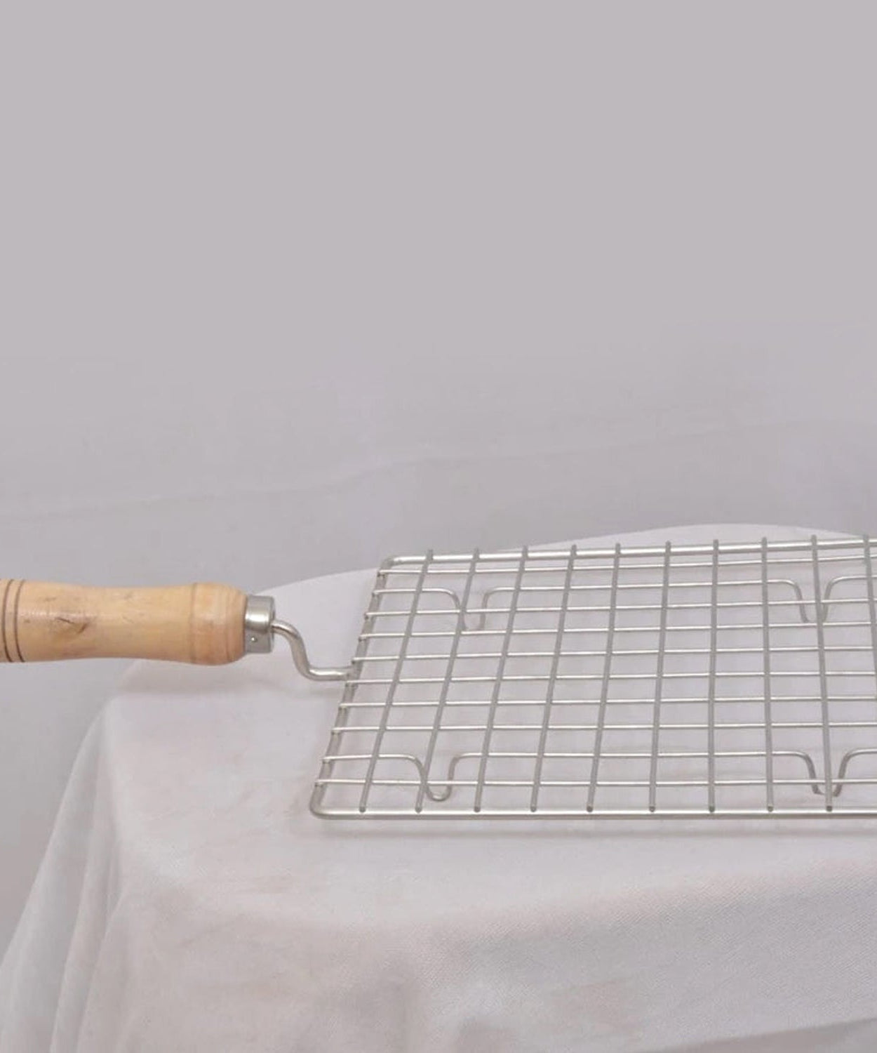 Barbecue grill with square stainless steel mesh and wooden handle.