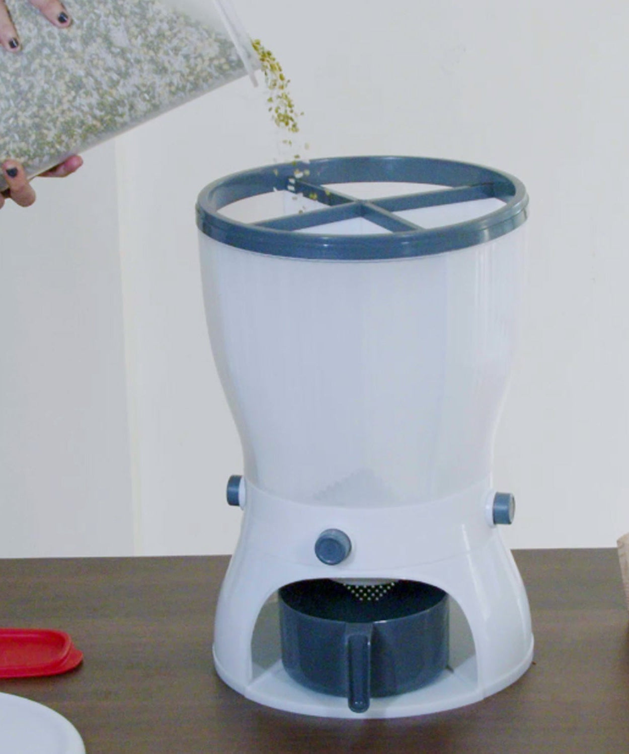 Dispenser with grains being poured out.