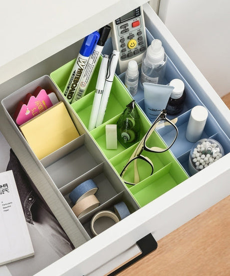 Clear plastic storage tray with dividers, used for organizing various small craft items.