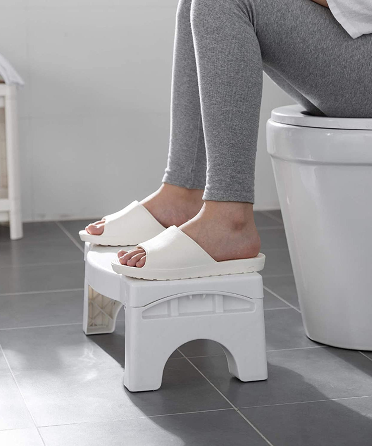 Compact white toilet squat stool with foldable and non-slip features.