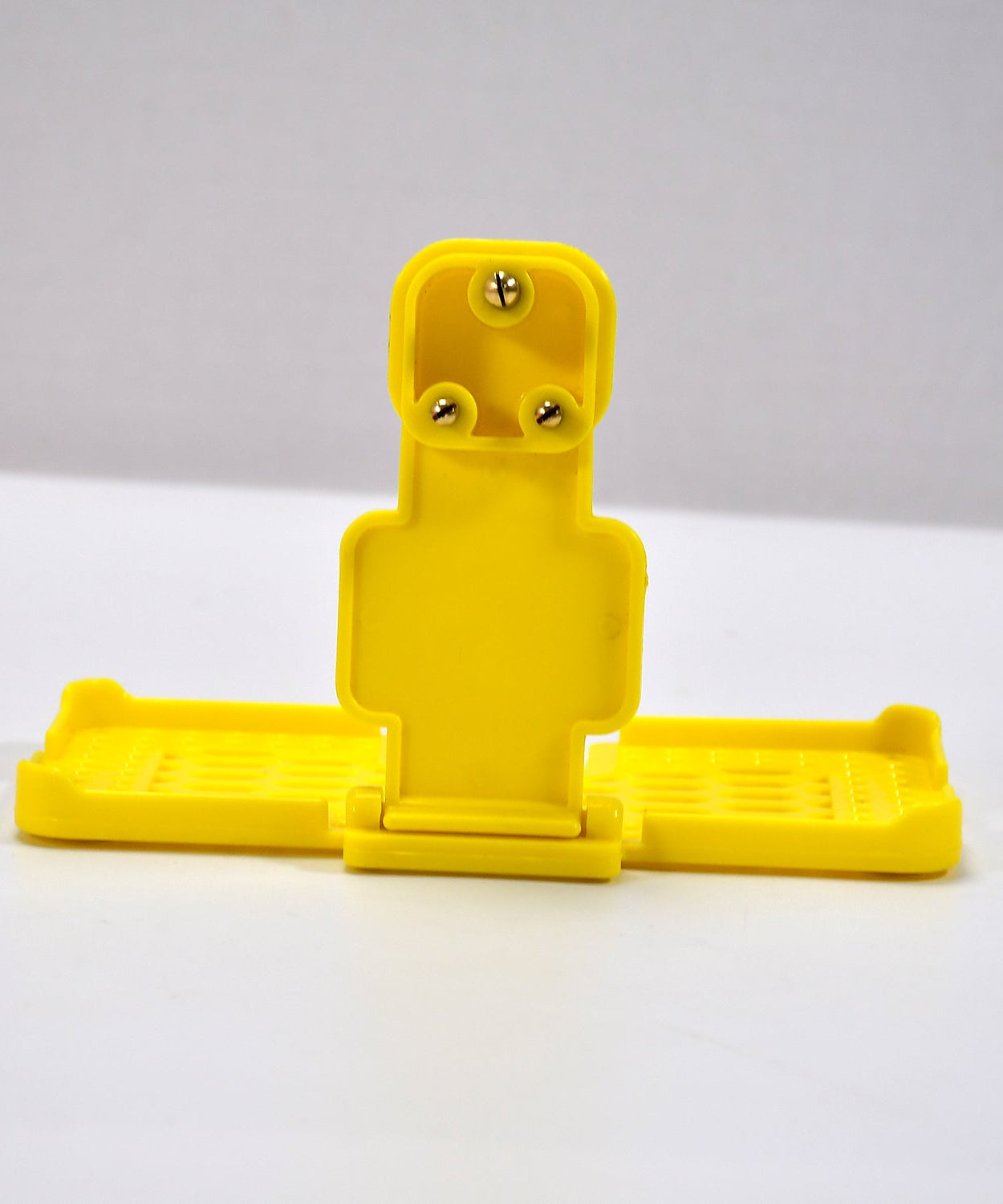 Yellow mobile holder for wall socket.