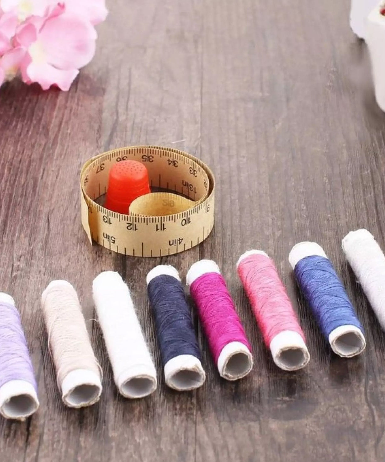 Detailed view of a sewing box with spools of thread and sewing notions neatly arranged.