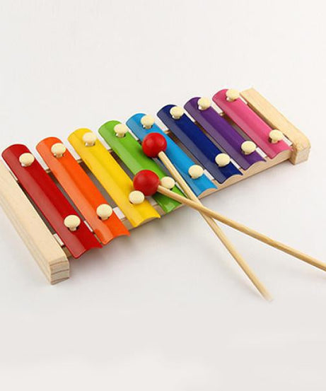 Xylophone with mallet on a white background, highlighting the wooden design