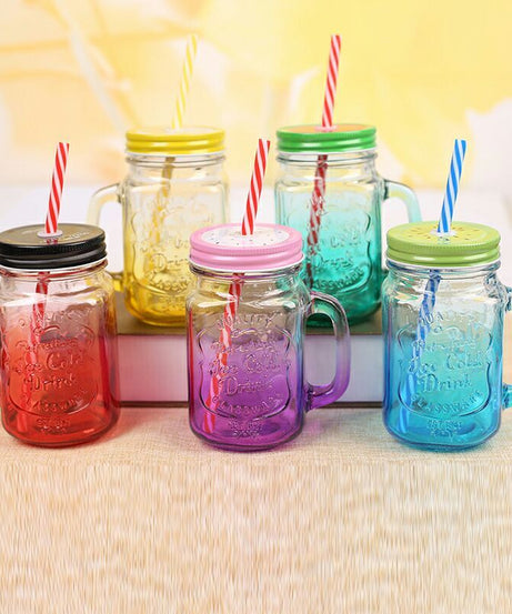 Clear glass mason jar with handle and straw, versatile for cold drinks and cocktails.